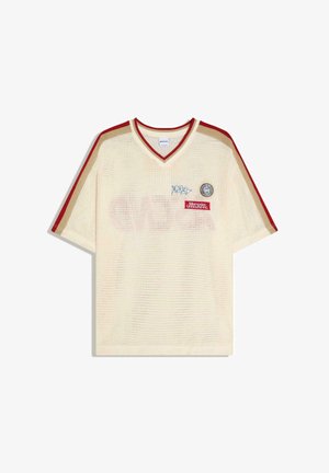 Cremefarbenes Mesh-Kurzarmshirt mit roten und beigen Streifen an den Ärmeln, einem V-Ausschnitt und drei Aufnähern auf der Brust.