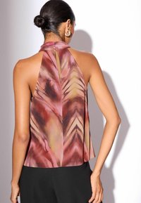 Vista posteriore di un top senza maniche a collo alto con un motivo astratto rosa e marrone, caratterizzato da un dettaglio a buco chiave al collo e un design fluido.