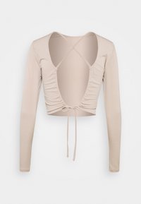 Long-sleeve, cropped top in soft beige material. Features a deep V-back with ruching and tie detail, highlighting a fitted design.