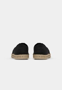 Svarta slip-on espadriller med ovandel i kanvas och sula av jute-rep. Har logodetalj på hälen, rund tå och flexibel konstruktion.