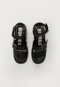 Svarta klumpiga klacksandaler med vida läderremmar, justerbar spänne, och vadderad innersula med "BUFFALO"-logotyp.