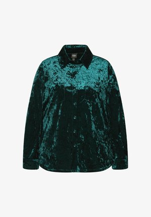 Teal fluwelen shirt met een kraag, voorzien van een knoopsluiting aan de voorkant, twee borstzakken en lange mouwen. De textuur lijkt zacht en glanzend.