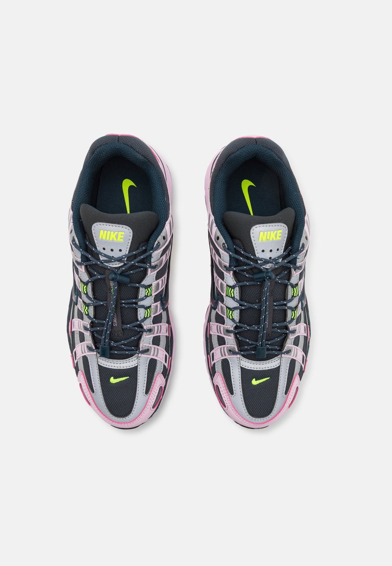Nike sneakers met een zwart, grijs en roze kleurenschema. Voorzien van ademend meshmateriaal, gelaagd ontwerp en een ronde neus. Groene logo-accenten.