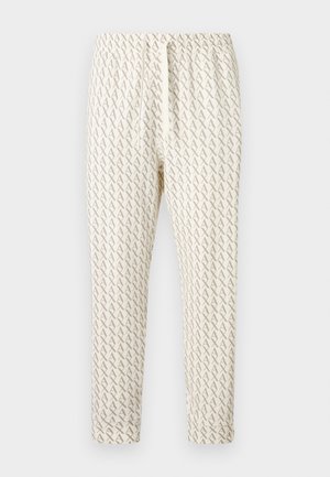 Heledad kreemikad vabaajapüksid, millel on kõikjal korduv pruun A muster, varustatud elastse vöökohaga ja reguleeritava nööriga.