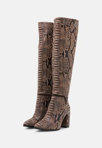 Bottes mi-mollet à talons carrés en matériau synthétique texturé, avec un motif léopard brun et noir. Fini lisse sur la pointe.