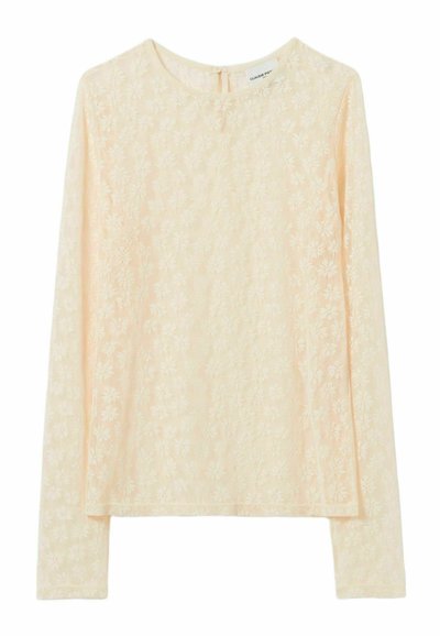 Top de encaje beige de manga larga con patrón floral, escote redondo y cierre de botón pequeño en la parte posterior.