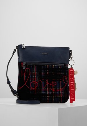 Crossbody bag with navy top, black plaid bottom embroidered with red "love" script, silver zipper pulls, and red rectangular keychain tag.