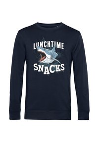 Sudadera de manga larga en color azul marino con el texto gráfico "SNACKS DE ALMUERZO" y una ilustración de un tiburón. Fabricada en un tejido suave con puños acanalados.