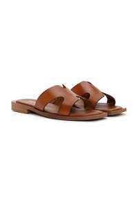 Bruna läder sandaler med platt sula, öppen tå och två breda remmar med utskurna mönster. Slät yta med minimal sömnadsdetaljer.