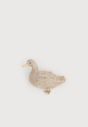Broche en forme de canard ornée de petits strass clairs et d'un seul strass bleu pour l'œil, sur un fond en métal doré.