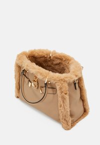 Borsa beige con bordi in pelliccia morbida e dettagli in metallo dorato, dotata di due manici con contorni neri e un dettaglio a lucchetto sul davanti.