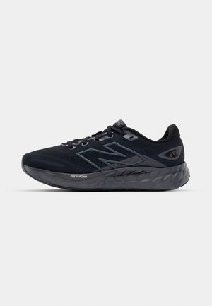 Herrarnas löparskor i svart mesh med en tjock grå sula, cirkulär struktur och reflekterande detaljer. Har "New Balance"-logotypen på sidan.