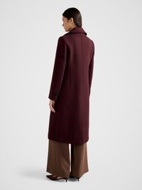 Maroon wool coat with a notched collar, long sleeves, and back vent. Paired with brown wide-leg trousers and brown pointed-toe shoes.