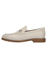 Beige leren instapper met een gladde afwerking, moccasin-stijl ontwerp en een zilverkleurige metalen accenten op de bovenkant. Bruine rubberen zool.