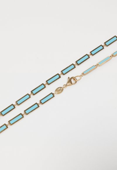 Auksinės spalvos grandinėlė, su stačiakampiais žiedais, įdėtais turkio emaliu. Įeina krabų užsegimas ir mažas etiketės detalė.