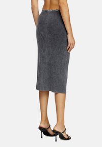 Gray ribbed knit midi skirt, fitted design with a waistband featuring a contrasting pattern, paired with black high-heeled sandals.