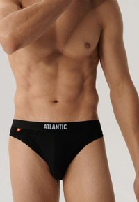 Czarne męskie majtki z elastycznym paskiem, na którym widnieje nazwa marki "ATLANTIC" w białym kolorze. Gładki materiał, standardowy krój, minimalistyczny design.