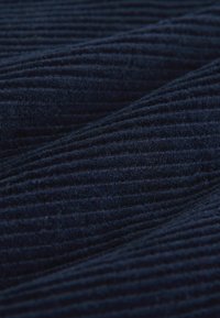 Ciemnogranatowa, prążkowana tkanina o miękkiej strukturze, z pionowymi liniami tworzącymi falisty wzór na całej powierzchni materiału.