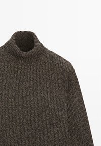 Pull à col roulé en maille côtelée gris foncé avec manches longues et fil épais texturé.