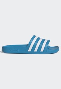 Blauwe rubberen slide-sandaal met drie witte diagonale strepen op de band en een gegraveerd logo aan de zijkant. Flat profiel en gestructureerde bovenkant.