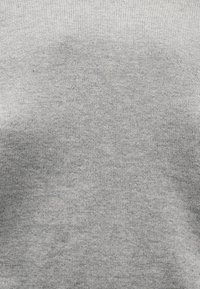 Ανοιχτό γκρι πλεκτό ύφασμα με λεπτή, ομοιόμορφη υφή που καλύπτει ομοιόμορφα την επιφάνεια.