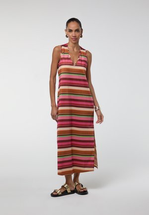 Mujer con un vestido sin mangas, de escote en V y longitud hasta el tobillo con rayas horizontales rosas, marrones y verdes, combinado con sandalias doradas y accesorios.