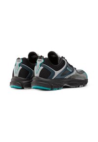 Une paire de baskets de sport noires, grises et turquoise avec un tissu en maille, de grosses semelles noires et le logo Reebok à l'arrière et sur le côté.