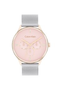 Calvin Klein klokke med bezel i roségull, rosa urskive, tre sub-dials og sølv mesh-reim. Har krystall detaljer på bezel.