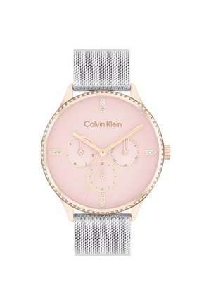 Calvin Klein klokke med bezel i roségull, rosa urskive, tre sub-dials og sølv mesh-reim. Har krystall detaljer på bezel.