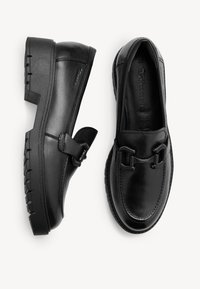 Černé kožené mokasíny s kulatou špičkou, texturovanou podešví, detaily s přezkou a jemným prošíváním. Placka s pohodlným střihem.