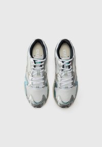 Sneakers z siateczkową cholewką z srebrnymi, turkusowymi i białymi akcentami. Okrągły nosek, płaskie sznurowadła i widoczny logo na języku.