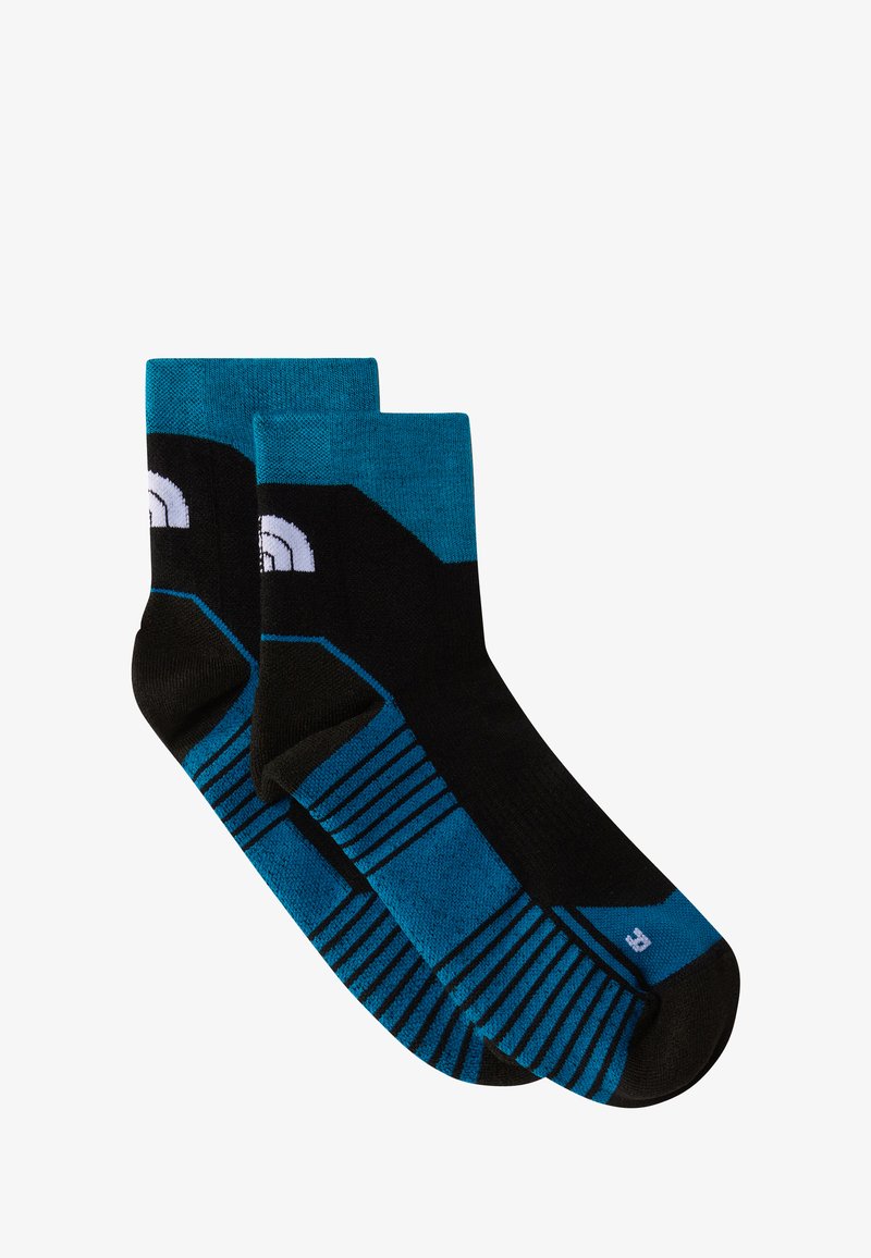 Czarne i turkusowe skarpetki w paski. Wyróżniają się jednolitym wykończeniem przy górze, czarną piętą i palcami oraz białym logotypem. Długość do połowy łydki.