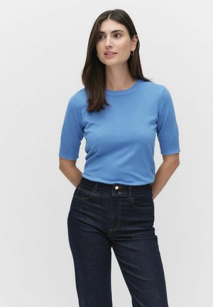 Lichtblauwe korte mouw gebreide trui met een ronde halslijn, gecombineerd met donkere jeans. De stof lijkt glad met een aansluitend ontwerp.