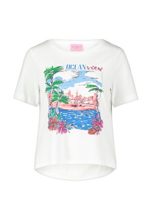 T-shirt blanc à manches courtes avec un graphique coloré d'une scène de plage, comprenant des palmiers, de l'eau et des fleurs. Texte "VUE sur l'OCEAN" inclus.