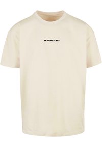 Cream-colored T-shirt made of cotton, featuring short sleeves and a crew neck. Includes a black printed logo on the front.