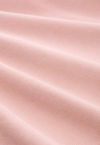 Weiches, pinkes Gewebe mit einer gerippten Struktur, das mehrere Falten zeigt und eine glatte Oberfläche hat. Gleichmäßige Farbe ohne sichtbare Muster.