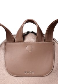 Brown leather backpack with textured finish. Features dual top handles, a rounded shape, and a front flap with embossed logo and silver accents.