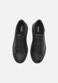 Czarne sneakersy ze skóry z fakturowanymi powierzchniami, sznurowanym designem, wyściełanym kołnierzem oraz złotym tłoczonym logo "GEOX RESPIRA" na wkładkach.