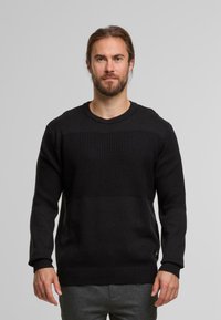 Schwarzer Strickpullover mit strukturierten horizontalen Streifen, gerippten Bündchen und Saum. Der Stoff wirkt weich mit einem klassischen Rundhalsausschnitt-Design.