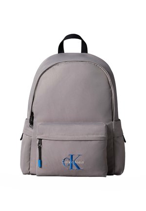 Gray Calvin Klein backpack with front zip pocket, black handle, side pockets, and blue CK logo on front pocket.