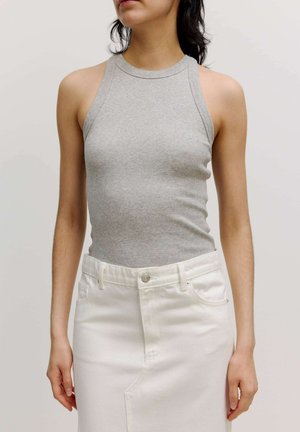 Grijze geribbelde tanktop met een hoge hals en mouwloos ontwerp, gecombineerd met een witte denimrok met voorzakken en een knopen sluiting.