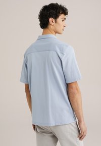 Camicia azzurra a maniche corte con colletto, caratterizzata da una superficie liscia e un dettaglio della cucitura della spalla posteriore, completata da un orlo dritto.
