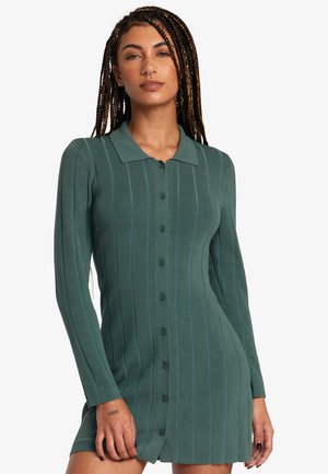 Vestido de punto acanalado verde con un frente abotonado, cuello, mangas largas y rayas verticales. Textura suave y longitud por encima de la rodilla.