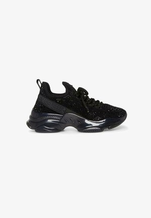 Las zapatillas deportivas negras cuentan con una parte superior de tela texturizada con acentos brillantes, una suela gruesa y brillante, y un dedo del pie redondeado.