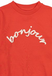 Červená bavlnená mikina s bielym vyšitým textom "bonjour" v zakrivenom dizajne na prednej strane. Štruktúrovaná tkanina a rebrovaný výstrih.