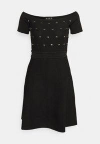 Robe noire décolletée avec des manches courtes, corsage ajusté, jupe évasée, tissu texturé et touches métalliques dorées.