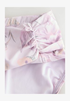 Lilla badedragt med blomsterprint og en rynket sløjfedetail ved taljen. Glat tekstur med et strækbart, let stof.