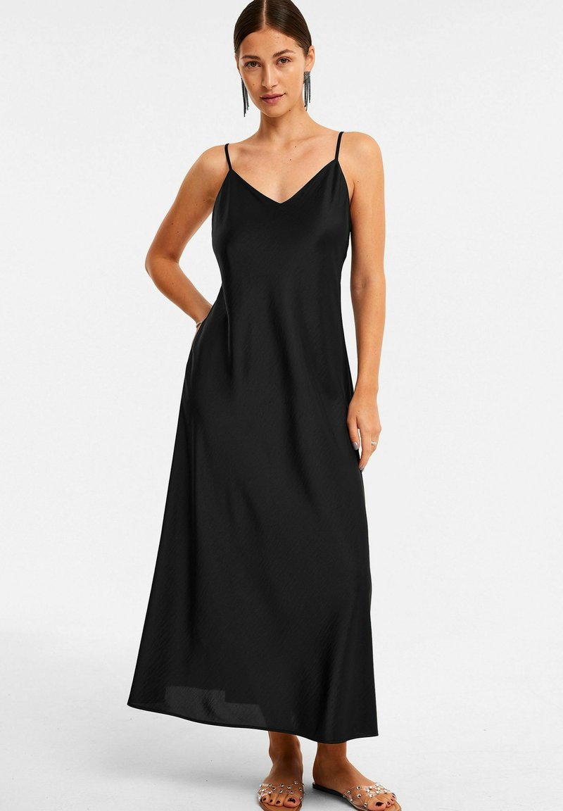 Schwarzes Maxikleid mit dünnen Trägern, einem V-Ausschnitt und einer fließenden Silhouette. Hergestellt aus leichtem Stoff mit einer glatten Textur.