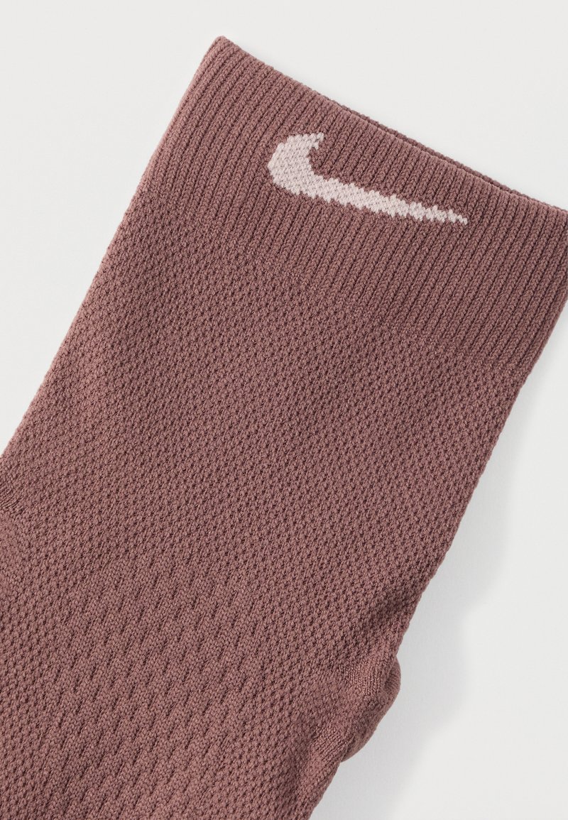 Calzino sportivo Nike color bordeaux, con trama a coste, punta rinforzata e logo rosa chiaro sul polsino.
