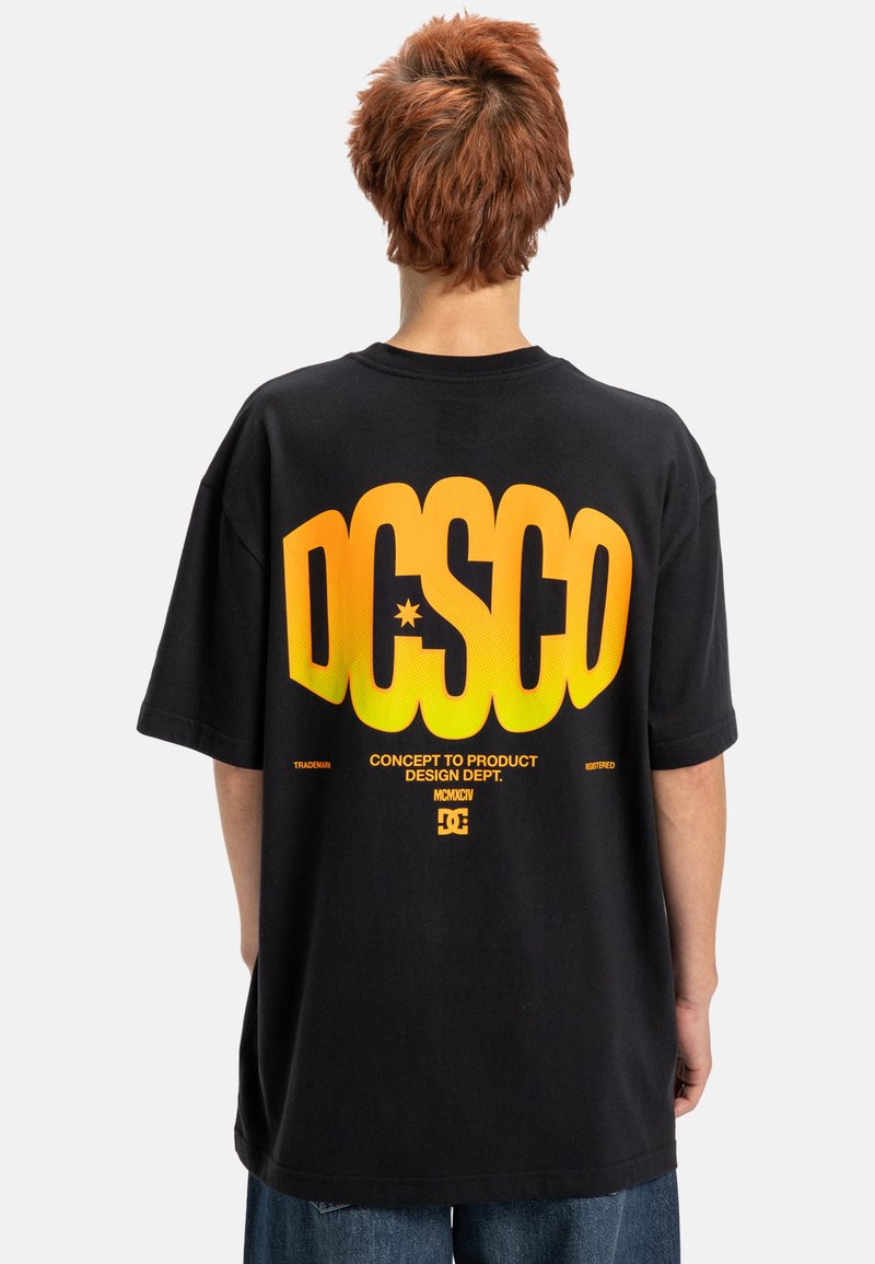 Zwarte t-shirt met gedurfde geel-oranje gradient tekst op de achterkant. Ruime pasvorm met korte mouwen en een standaard ronde hals.